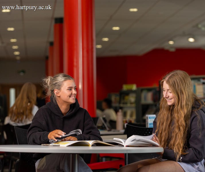 College Student Sat In Library With Friend