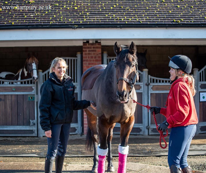Two students with a horse in the Equine Yard