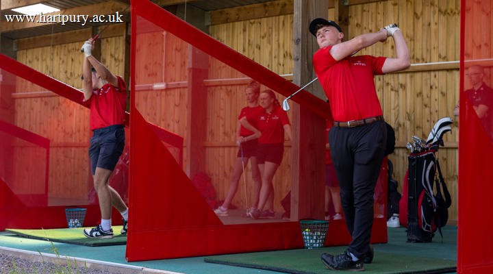 Male Student Practising In Golf Driving Range