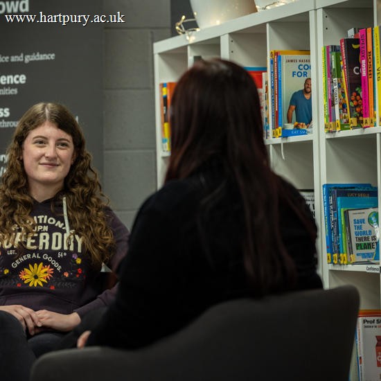 Student Support staff member sat opposite a student