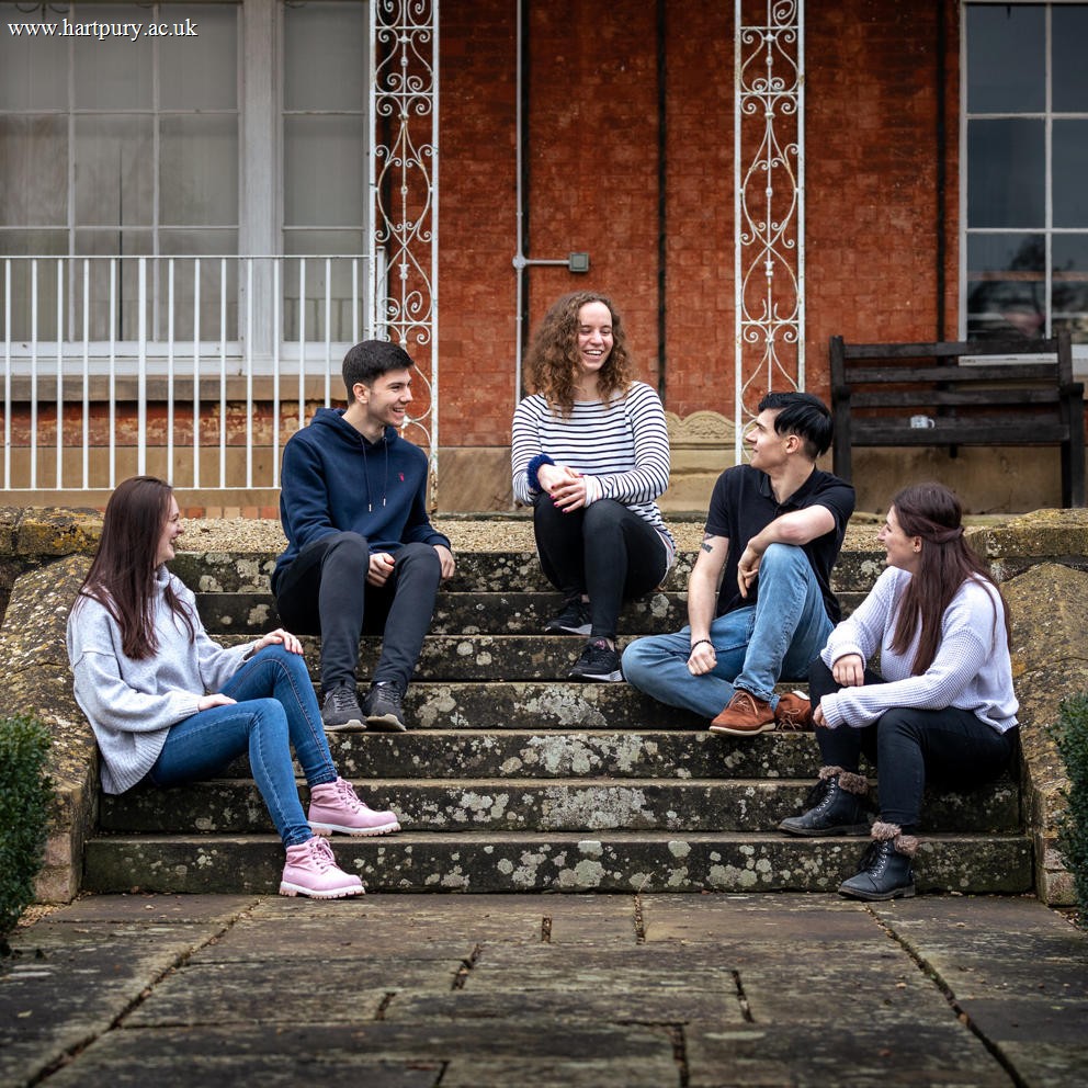 Students Sat On Steps Outside Hartpury House